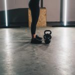 woman in black tank top and black leggings standing on white floor